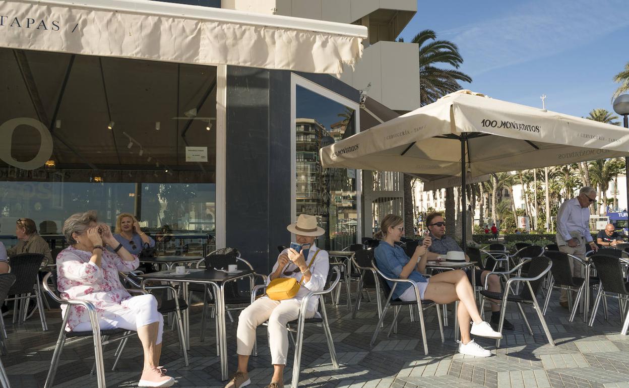 Una terraza con turistas en el paseo de la playa del Postiguet 