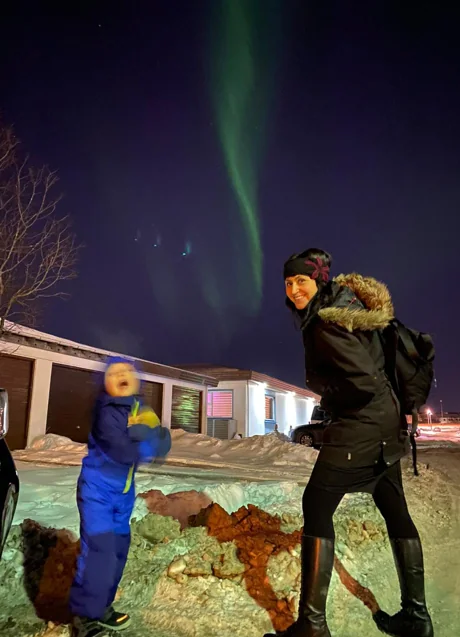 Imagen - Sofía y su hijo observan una aurora boreal en el jardín de su casa nevado.