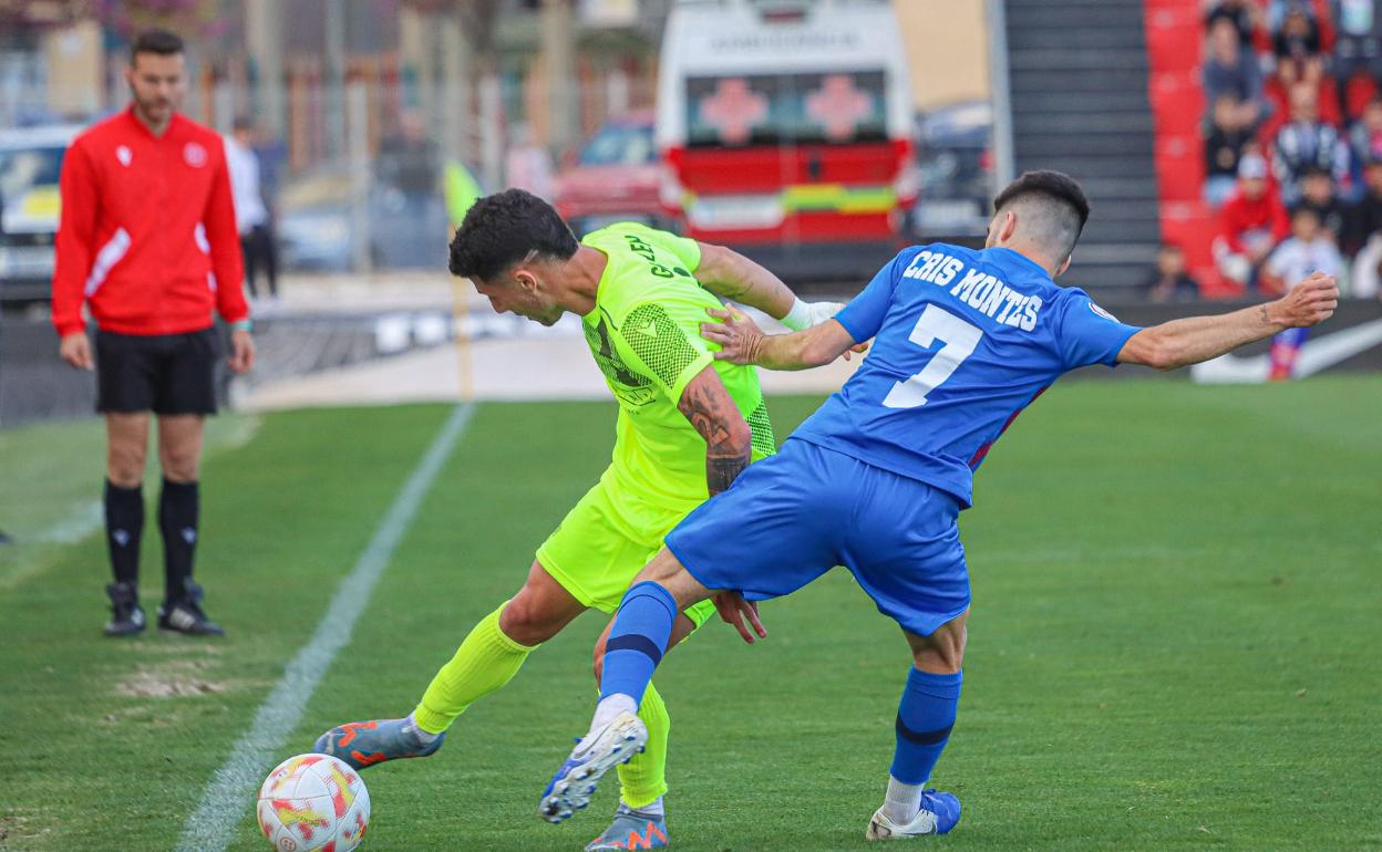 Guillem Jaime protege un balón ante el autor del primer gol del partido Cris Montes. 