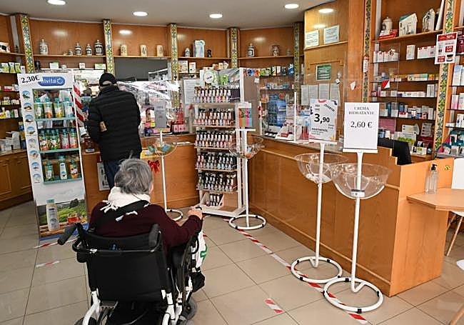 Clientes haciendo cola en una farmacia de Alicante.