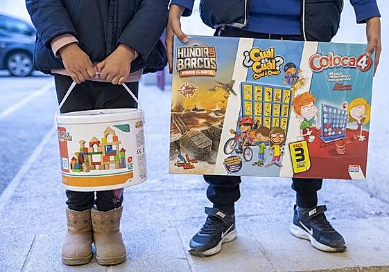 Dos niños con juguetes en la recogida solidaria.