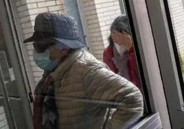 Dos mujeres entran en un centro de salud con mascarillas.