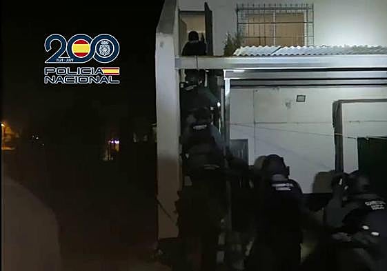 Los agentes entran en una de las viviendas de los sospehosos.