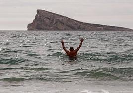 Un hombre se baña en la playa de Levante de Benidorm.