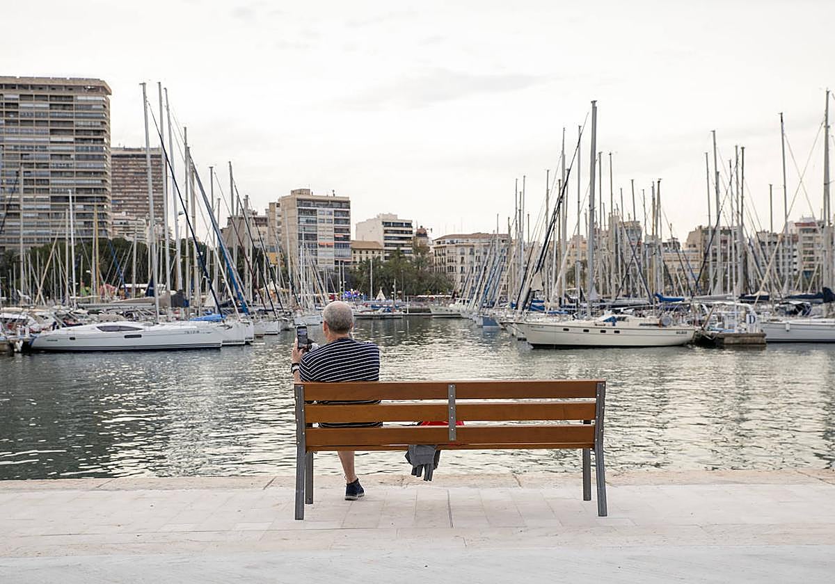 Un hombre fotografía el Puerto de Alicante.