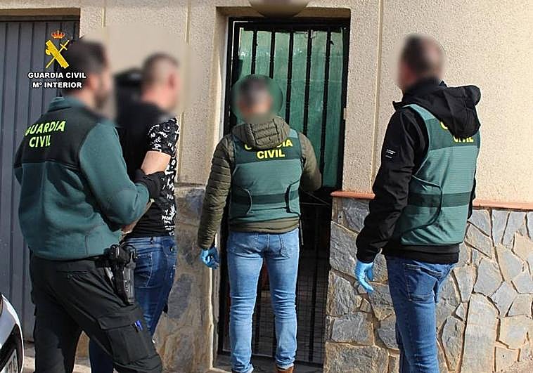 La Guardia Civil, con uno de los detenidos, en un registro domiciliario.