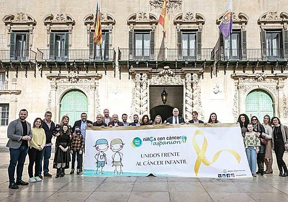 Despliegue de una gran pancarta con un lazo dorado en la plaza del Ayuntamiento