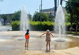 Dos niños se refrescan en una fuente de Alicante el pasado verano