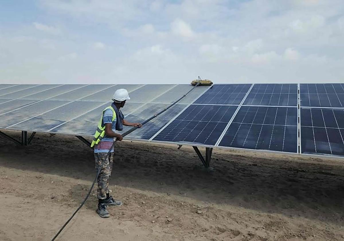 Un operario limpia unas placas solares.