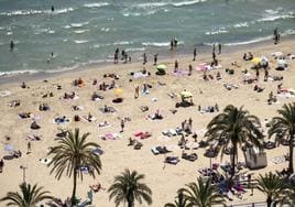 Bañistas y gente tomando el sol y disfrutando de la playa del Postiguet en Alicante.