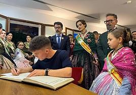 Dani Holgado firma en el libro de honor de San Vicente ante la mirada de autoridades festeras e institucionales.