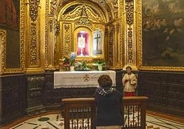 Una mujer reza en el camarín de Santa Faz.