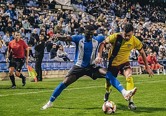 Marcos Mendes protege el balón ante un jugador del Alzira.