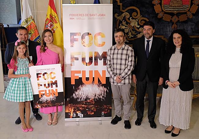 Seva junto a su cartel, acompañado de las belleas del foc, el alcalde, la concejala de Fiestas y el presidente de la Federació.