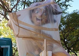Un ninot, envuelto en plástico espera para ser colocado en la foguera.
