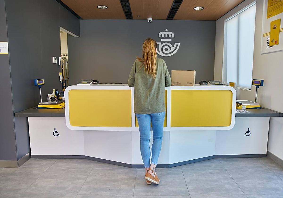 Una mujer en una oficina de Correos.