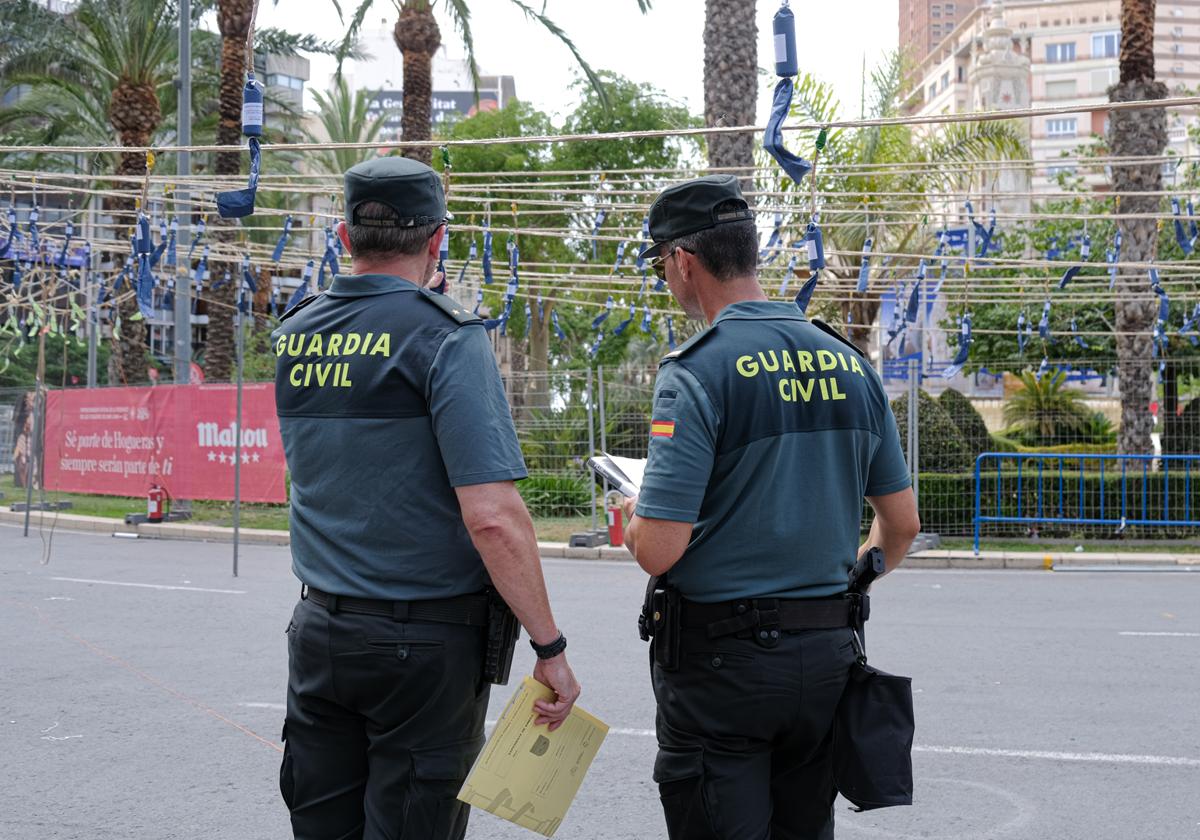 Dos agentes de la Unidad de Intervención de Armas y Explosivos revisan la mascletà antes de su disparo.