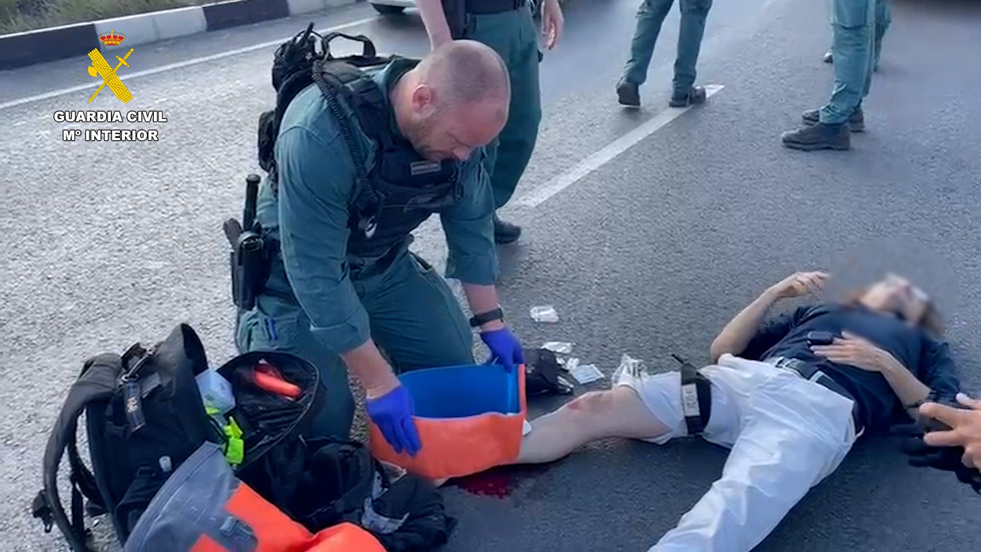 Imagen principal - Guardias civiles realizan un torniquete a un motorista que se destrozó la pierna tras un accidente en Torrevieja