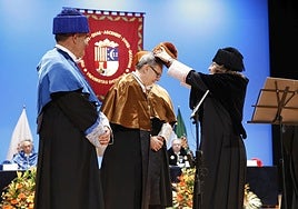 La rectora de la UA, Amparo Navarro, impone el birrete al doctor 'honoris causa' Pedro Castro, en el acto celebrado este jueves.