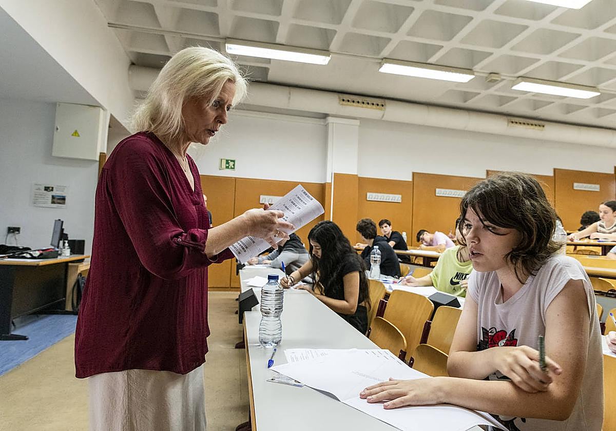 Docente repartiendo un examen.