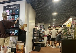 Jóvenes se resguardan del calor en comercios de Alicante.