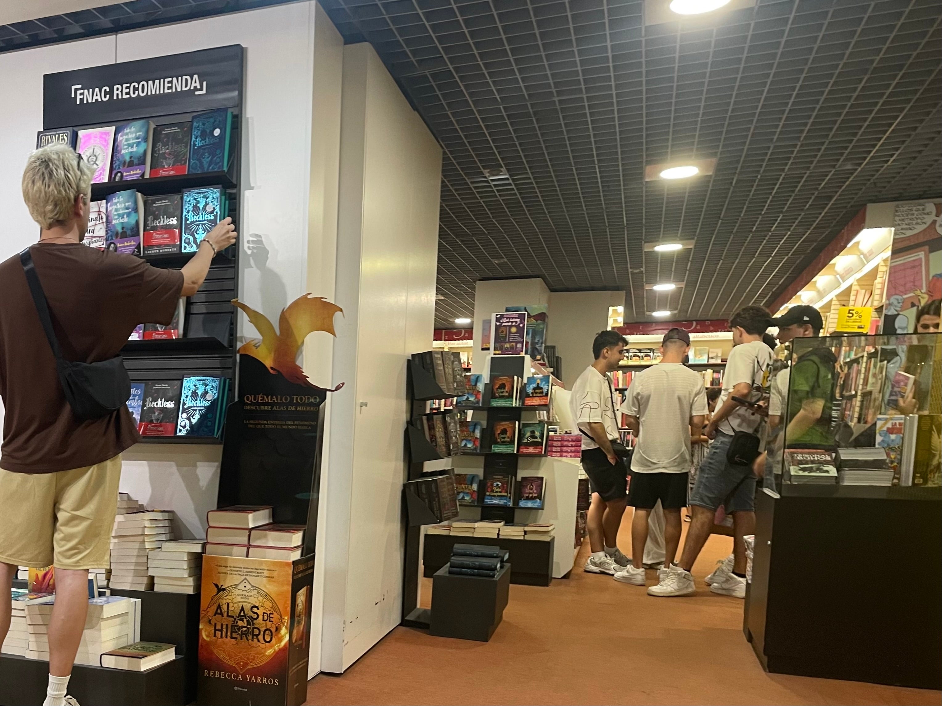 Jóvenes se resguardan del calor en comercios de Alicante.