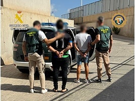 Dos agentes de la Guardia Civil custodian a los dos presuntos ladrones.