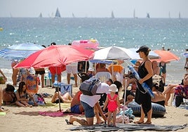 Una familia en la playa del Postiguet de Alicante.