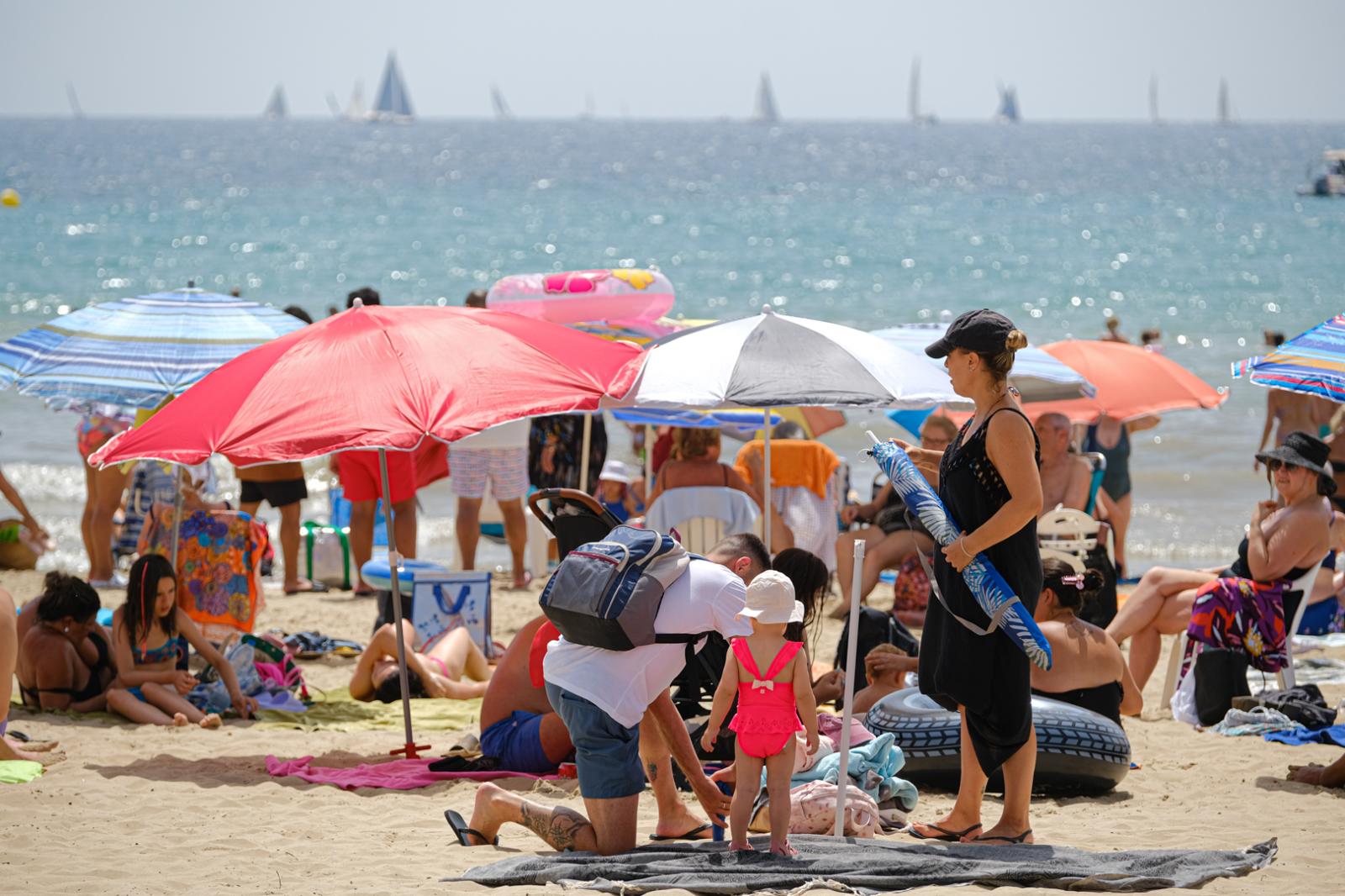 Una familia en la playa del Postiguet de Alicante.