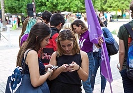 Estudiantes de la UA utilizan sus teléfonos móviles.