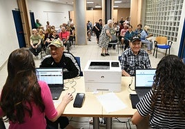 Dos personas compran sus Bono Comercio Sénior en el Cerca de Alicante, en el Mercado Central.