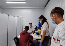 Técnicos de Cruz Roja examinan a un migrante recogido en una embarcación precaria en Alicante, en imagen de archivo.