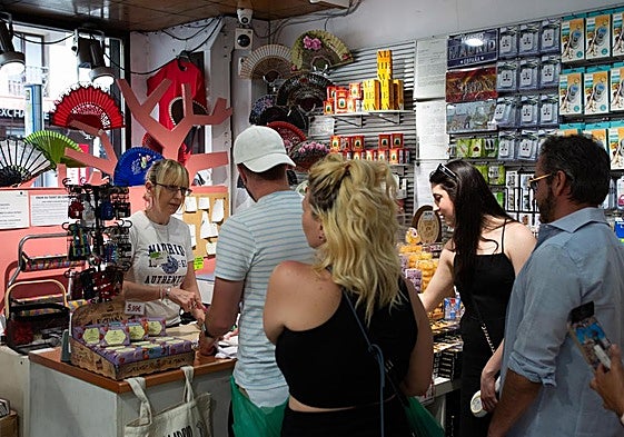 Una dependienta atiende a unos clientes en una tienda.