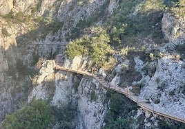 Obras, al fondo, en la pasarela del pantano de Relleu.