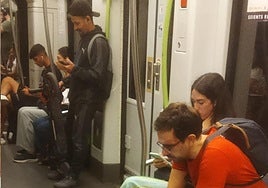 Un viajero porta su patinete plegado en un tranvía.