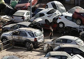 Un hombre camina entre los coches amontonados en una calle en Paiporta, este jueves.