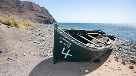 Una patera encallada en tierra.