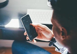 Un joven utiliza su teléfono móvil.
