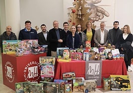 Dirigentes de la UMH junto a parte de los regalos recaudados.