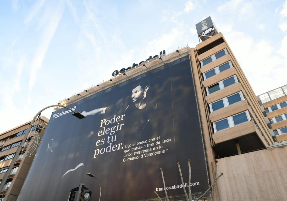 La fachada del Banco Sabadell en Alicante se encuentra empapelada con una gran pancarta en contra de la OPA de BBVA.