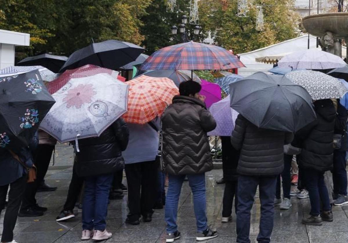 Un grupo de personas se protege de la lluvia.