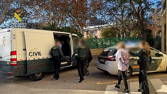 Agentes de la Guardia Civil custodian a dos de los detenidos en la operación.