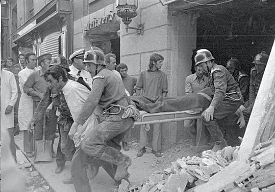 Bomberos y camilleros sacan un cuerpo de la cafetería Rolando.