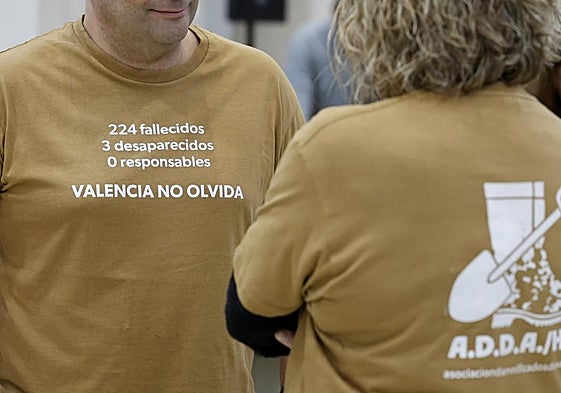 Dos personas vestidas con camisetas de la Asociación de Damnificados Horta Sud Valencia.