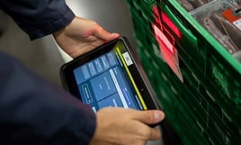 Un empleado de Mercadona trabaja con ayuda de un dispositivo inteligente.