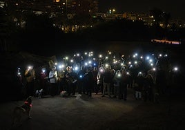 Los vecinos, con las linternas de los móviles, en la llamada 'Marcha de las Luciérnagas' este viernes.