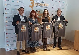 Organizadores de la Carrera de la Mujer posan con las camisetas.