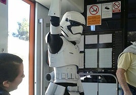 Una personas con un disfraz de soldado imperial de 'Star Wars' usando el Tram de Alicante.