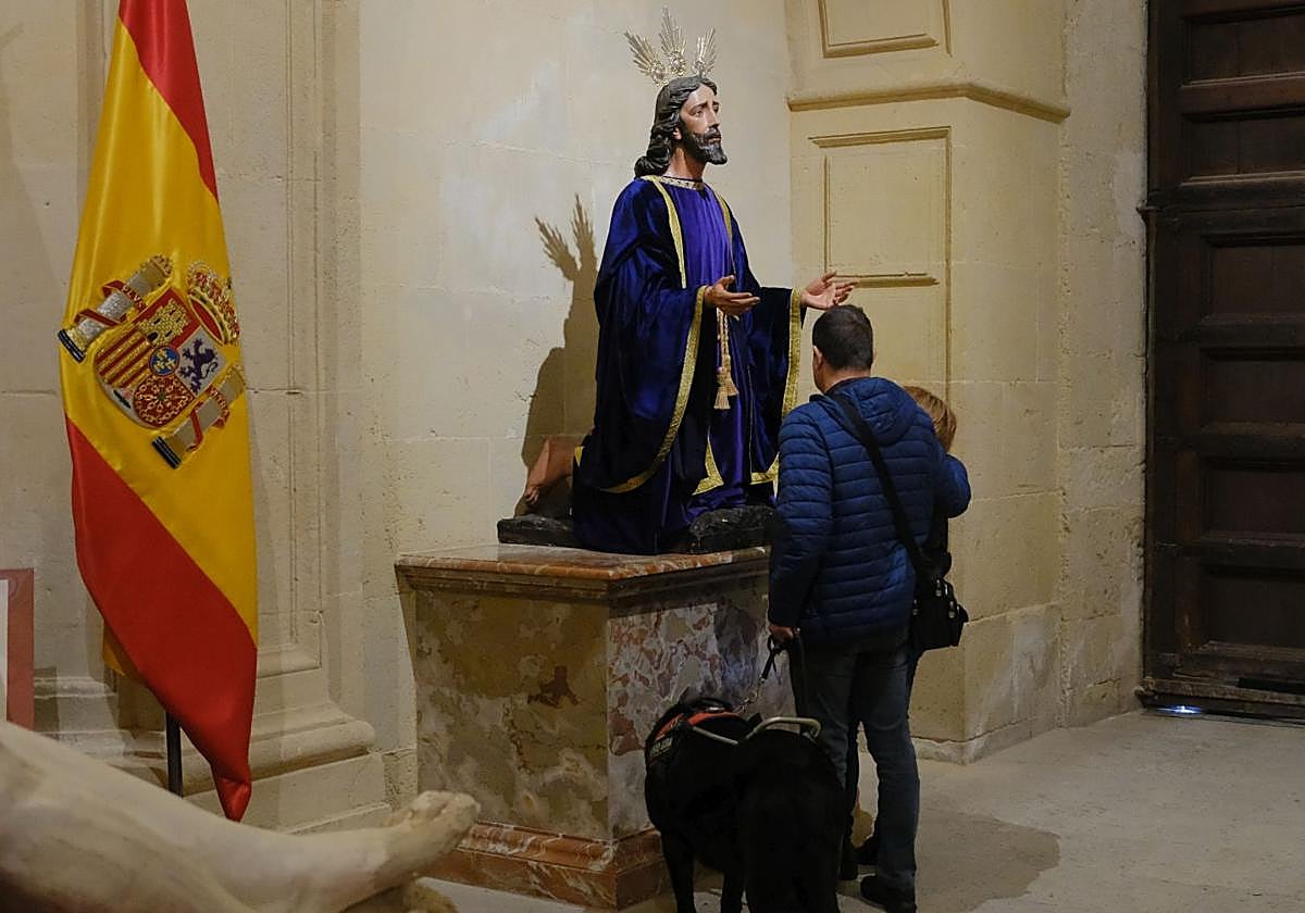 Un invidente frente a una de las imágenes de la Semana Santa en la concatedral de San Nicolás.
