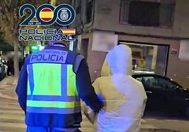 Un policía acompaña a uno de los arrestados.